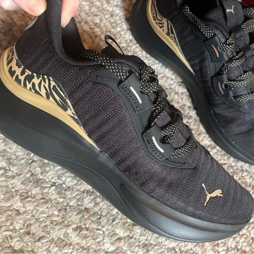Puma women’s Black and Gold Sneakers